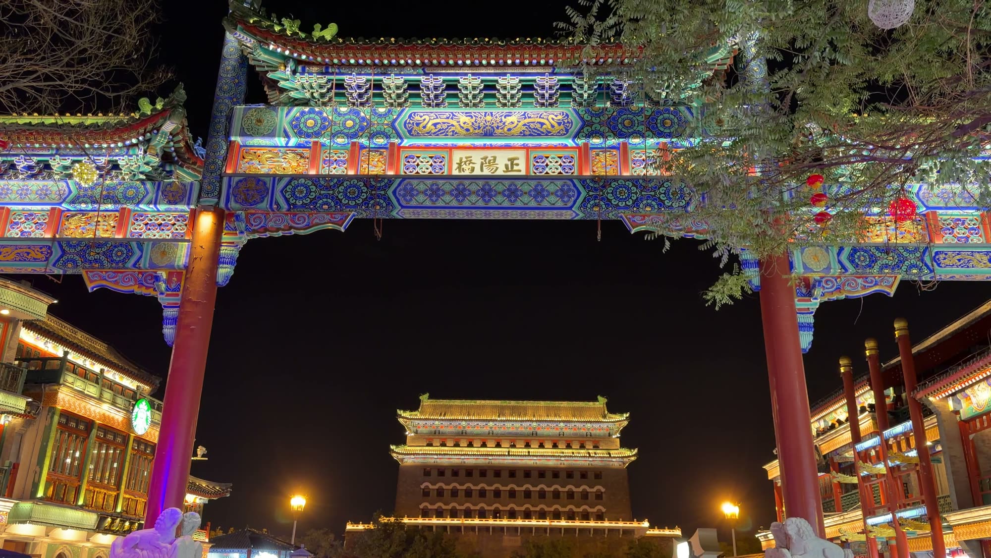 The painted archway on Qianmen Street at night, with the Zhengyangmen gate tower behind it